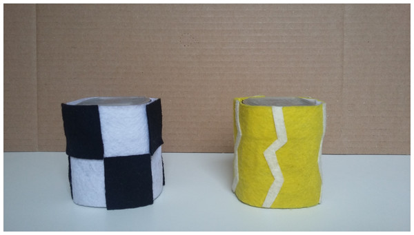 Two of the cups and felt sleeves in front of the occluder used in Experiment 2.