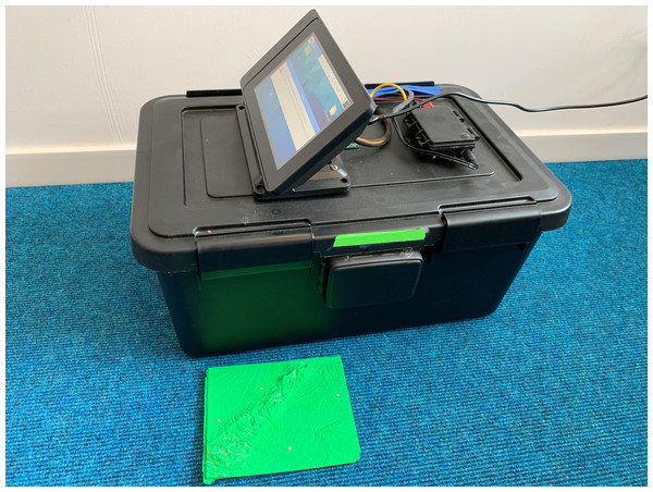 Photograph of the custom-designed and built Slime Mold Incubator Camera System (SMICS) used to capture the exploration of the slime mold over the 3D printed maps with one of the 12 cm × 15 cm maps included for scale.