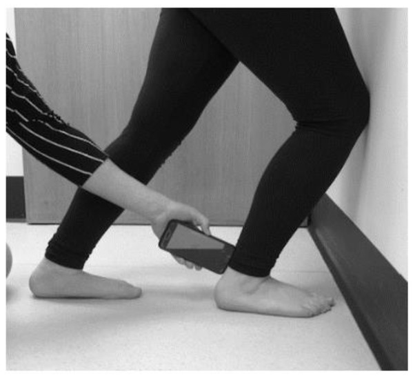 Position of weight bearing lunge test with iPhone positioning and screen positioning demonstrated (author’s own image).
